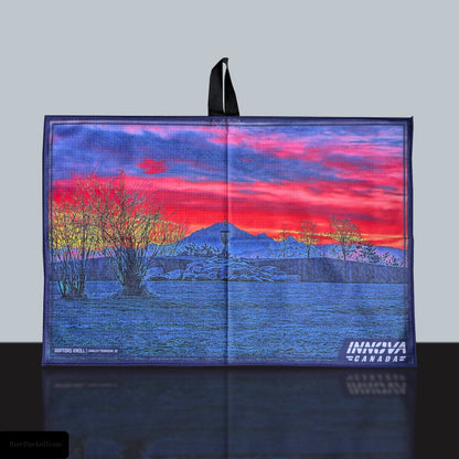 a disc golf towel featuring raptor's knoll sunrise